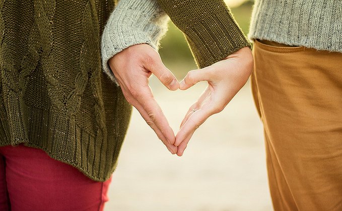 Homem e mulher com as mãos em forma de coração Homem e mulher com as mãos em forma de coração