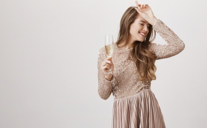 Mulher de vestido bege com uma taça de champanhe Mulher de vestido bege com uma taça de champanhe