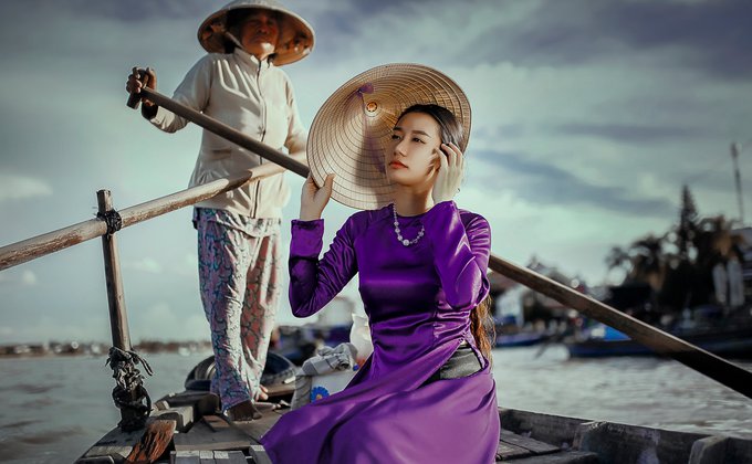 Mulher de vestido lilás no barco